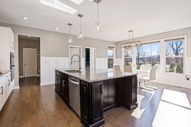 kitchen with decorative light fixtures, an island with sink, stainless steel appliances, and sink