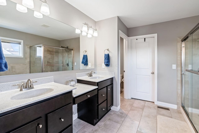 bathroom with tile patterned flooring, toilet, and a shower with shower door