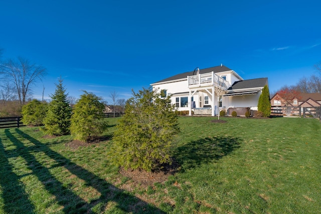 exterior space featuring a balcony and a front lawn