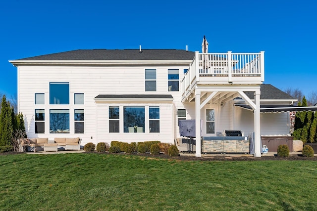 rear view of house featuring a lawn, an outdoor hangout area, a balcony, area for grilling, and a hot tub