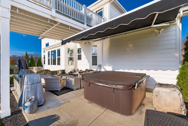 view of patio / terrace with outdoor lounge area, a balcony, and a hot tub