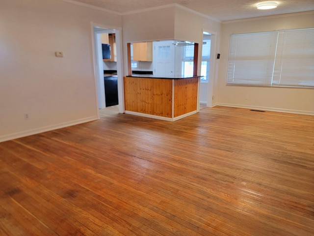 unfurnished living room featuring light hardwood / wood-style flooring and ornamental molding