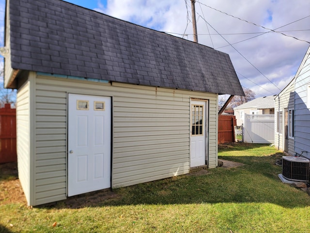 view of outbuilding with central AC unit and a lawn