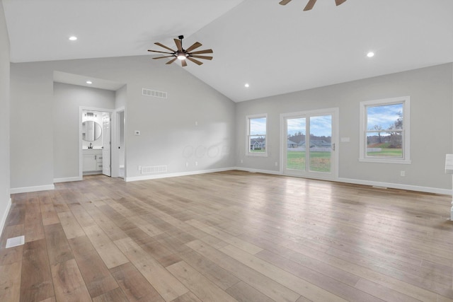 unfurnished living room with lofted ceiling, light wood-type flooring, sink, and ceiling fan