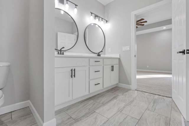 bathroom featuring toilet, ceiling fan, and vanity