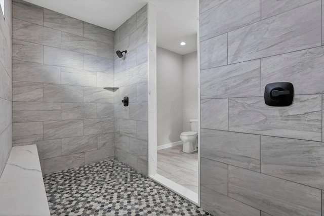 bathroom featuring toilet and a tile shower