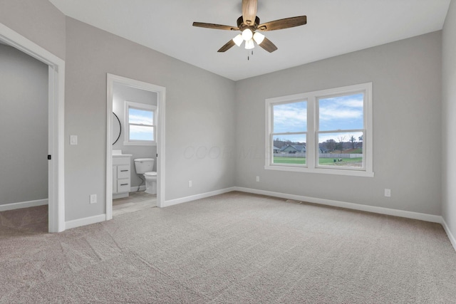 unfurnished bedroom with ceiling fan, carpet, and ensuite bath