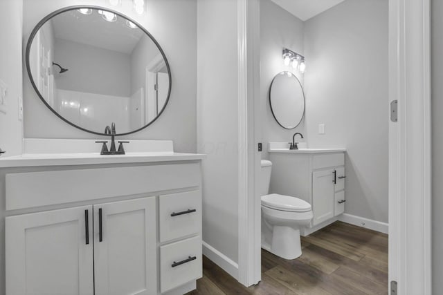 bathroom with wood-type flooring, toilet, and vanity