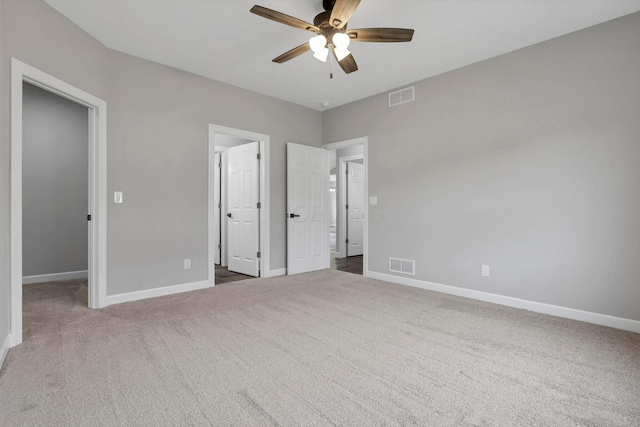 unfurnished bedroom featuring ceiling fan, carpet, and a walk in closet