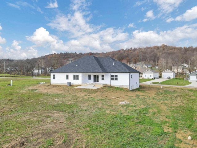 rear view of property featuring a patio area and a lawn