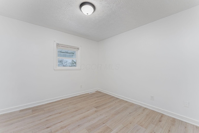 empty room featuring light hardwood / wood-style floors and a textured ceiling