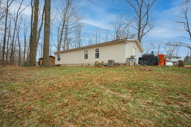 back of property with a yard and central AC unit