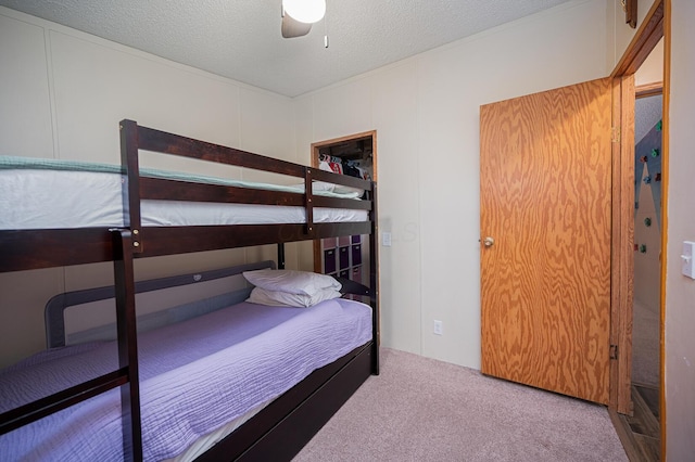 carpeted bedroom with ceiling fan and a textured ceiling