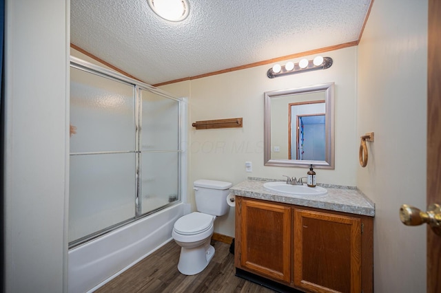 full bathroom with vanity, bath / shower combo with glass door, hardwood / wood-style flooring, ornamental molding, and a textured ceiling