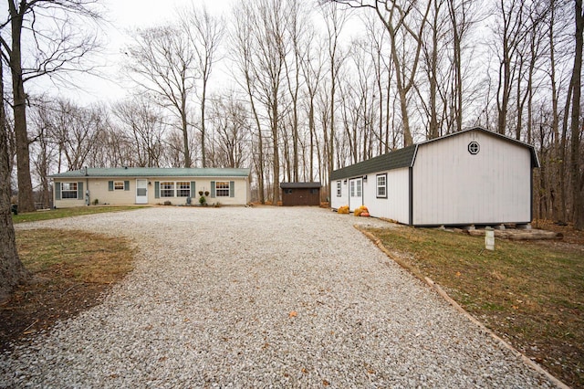 ranch-style home featuring a front yard and an outbuilding