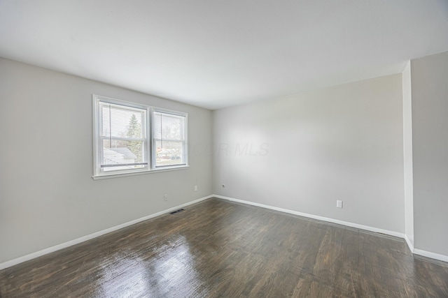 unfurnished room featuring dark wood-type flooring