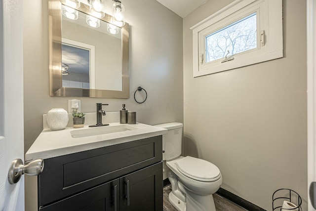 bathroom with hardwood / wood-style floors, vanity, and toilet