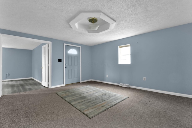 carpeted foyer entrance featuring a textured ceiling