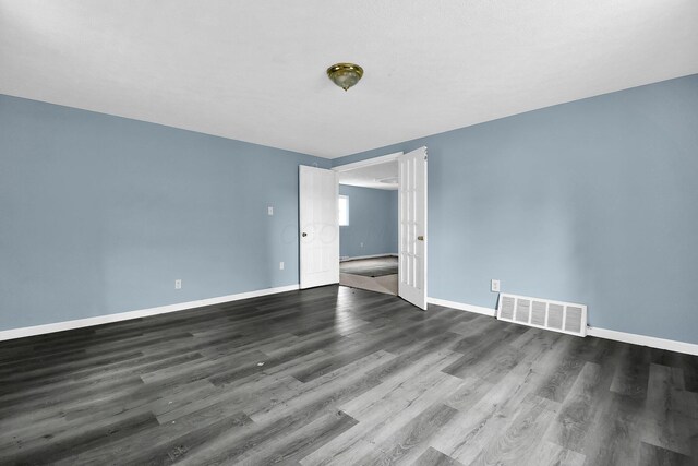 spare room featuring dark hardwood / wood-style flooring