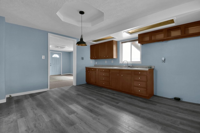 kitchen with dark wood-type flooring, pendant lighting, a textured ceiling, and sink