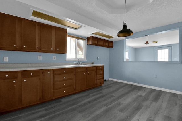 kitchen featuring hardwood / wood-style floors, a textured ceiling, hanging light fixtures, and sink