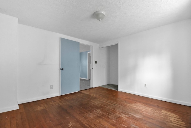 unfurnished room with wood-type flooring and a textured ceiling