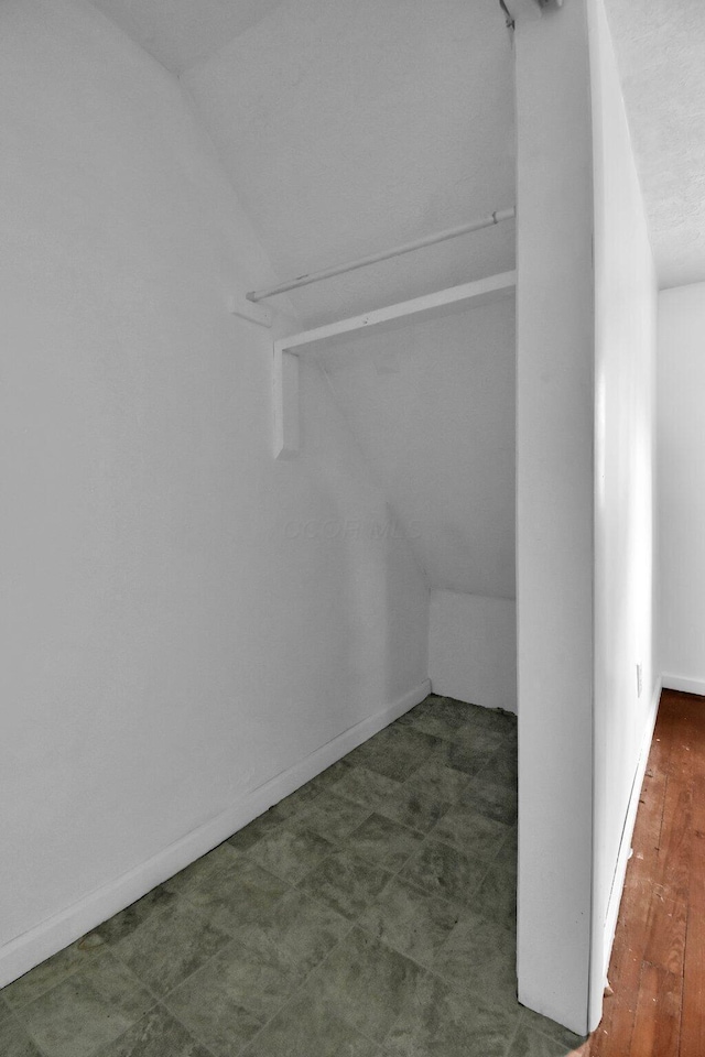 walk in closet featuring dark hardwood / wood-style flooring and lofted ceiling