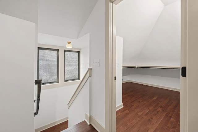 hall with dark hardwood / wood-style flooring and lofted ceiling