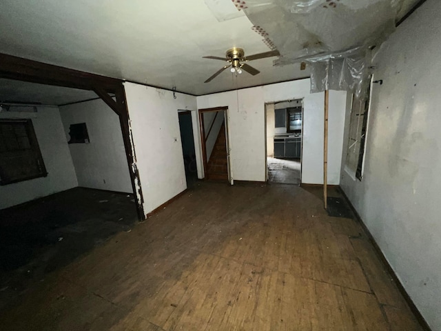 empty room with ceiling fan and dark wood-type flooring