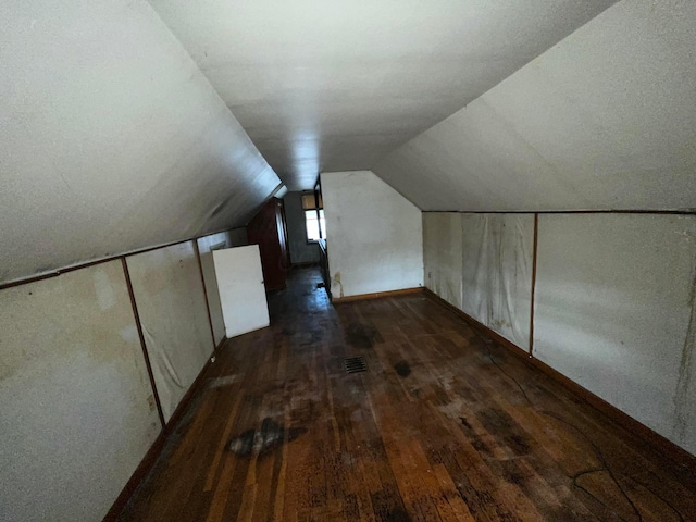 bonus room with lofted ceiling and dark hardwood / wood-style floors