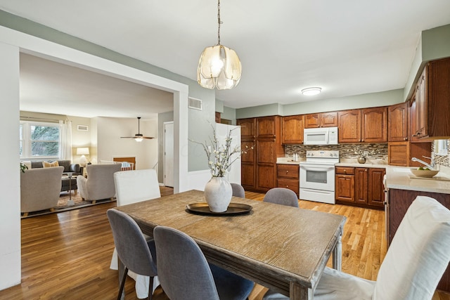 dining room featuring ceiling fan, sink, and light hardwood / wood-style flooring