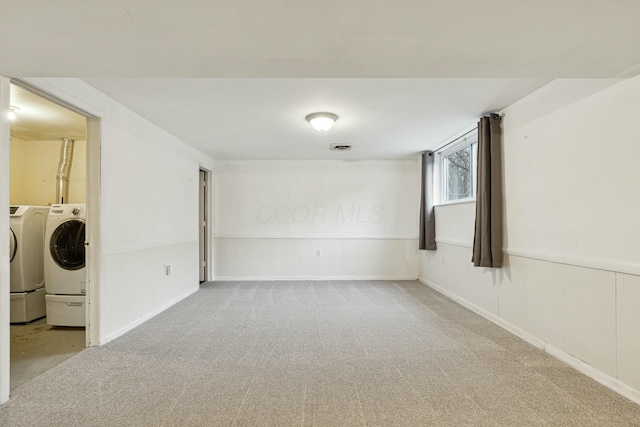 carpeted empty room featuring washing machine and dryer