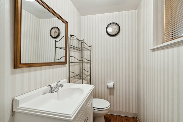 bathroom with hardwood / wood-style floors, vanity, and toilet