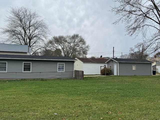 back of property featuring a lawn and an outdoor structure