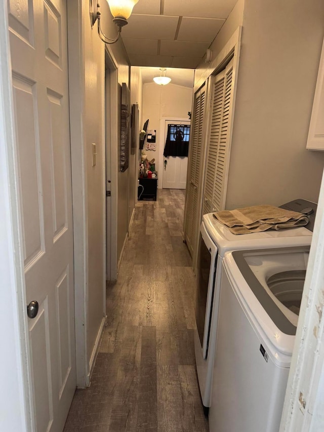 laundry room with washer and clothes dryer and dark wood-type flooring