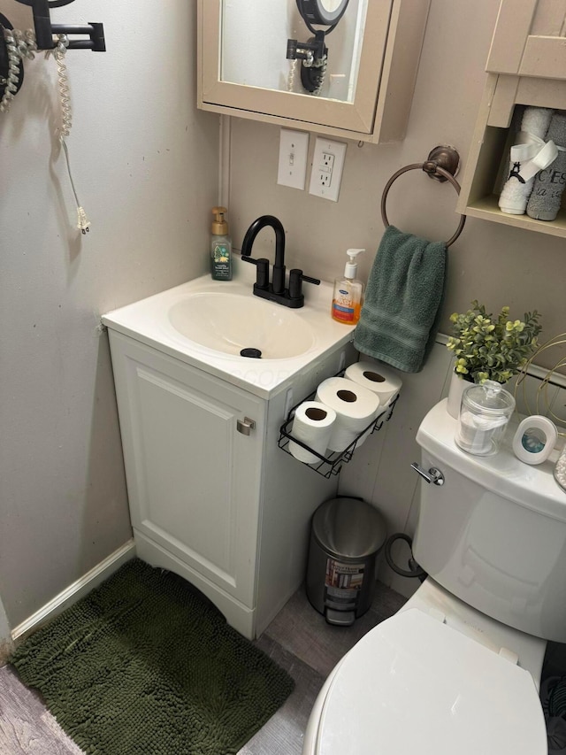 bathroom with hardwood / wood-style floors, vanity, and toilet