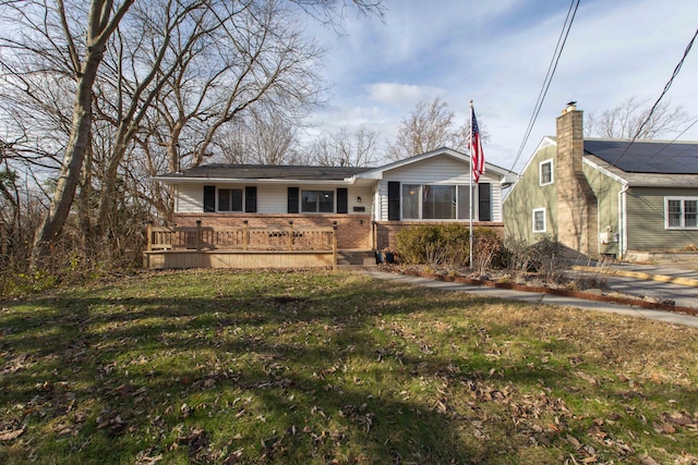 view of front of property with a wooden deck and a front yard