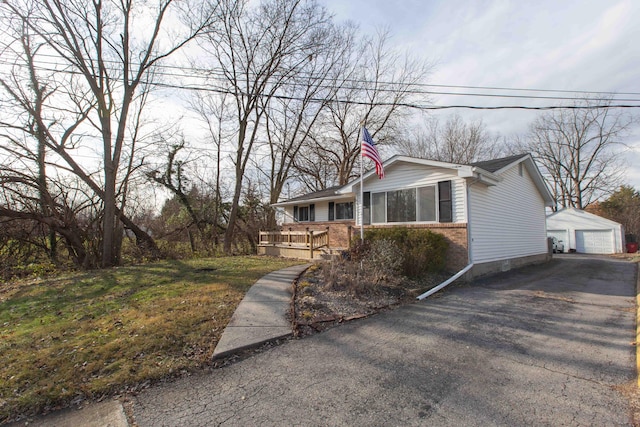 view of home's exterior with a lawn, a garage, and an outdoor structure