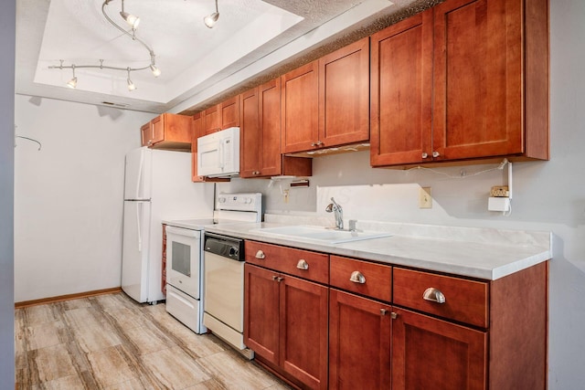 kitchen featuring sink, rail lighting, a textured ceiling, white appliances, and light wood-type flooring