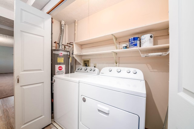 laundry area featuring a textured ceiling, washer and clothes dryer, gas water heater, and light wood-type flooring