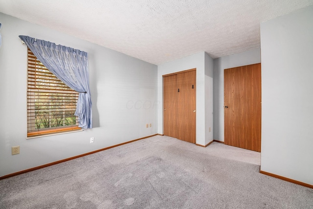 empty room with light carpet and a textured ceiling