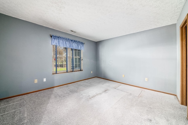 carpeted empty room with a textured ceiling