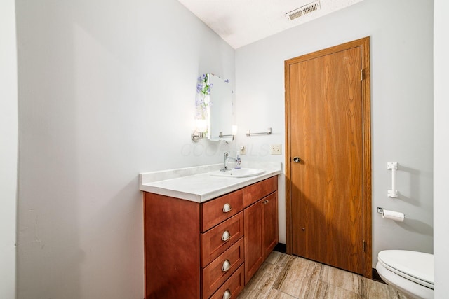 bathroom featuring hardwood / wood-style floors, vanity, and toilet