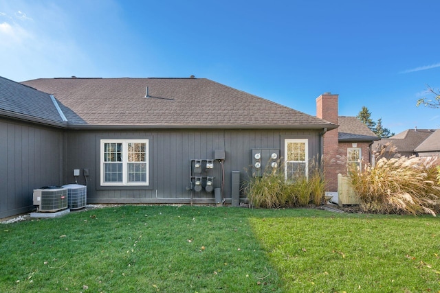 rear view of house with a yard and cooling unit