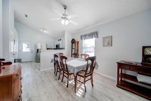 dining area with lofted ceiling, ceiling fan, a textured ceiling, and light wood-type flooring