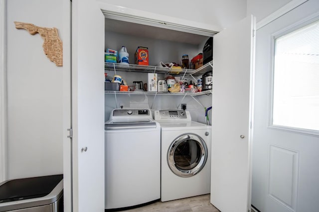 clothes washing area featuring washing machine and dryer, plenty of natural light, and light hardwood / wood-style flooring