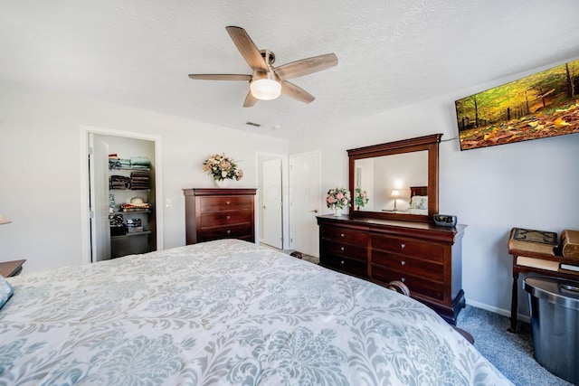 carpeted bedroom with ceiling fan and a textured ceiling