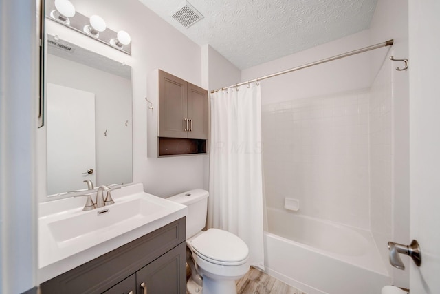 full bathroom with hardwood / wood-style flooring, vanity, toilet, shower / bath combo, and a textured ceiling