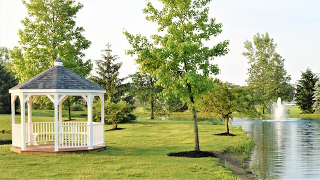 view of property's community with a gazebo, a water view, and a lawn