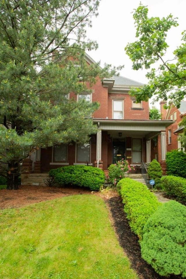 rear view of property with a porch and a yard